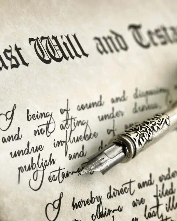A pen is on top of the last will and testament.