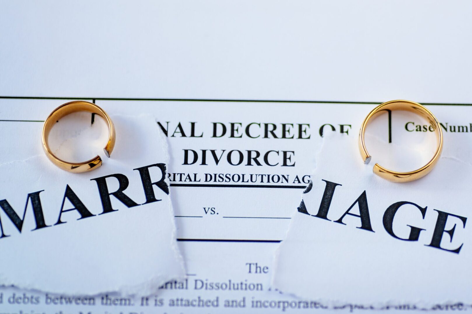 Divorce decree and two broken wedding rings. Divorce and separation concept