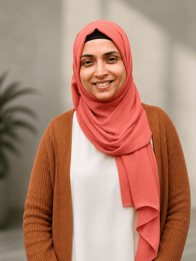Smiling woman in coral hijab and cardigan